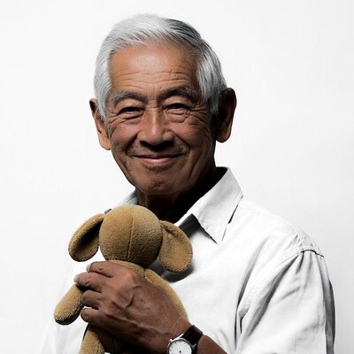 Elderly Asian man holding teddy bear