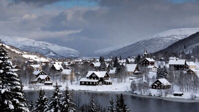 Snowy Norwegian village by frozen lake