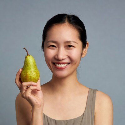 Asian woman holding green pear