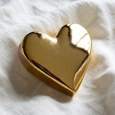 Shiny gold heart on white fabric