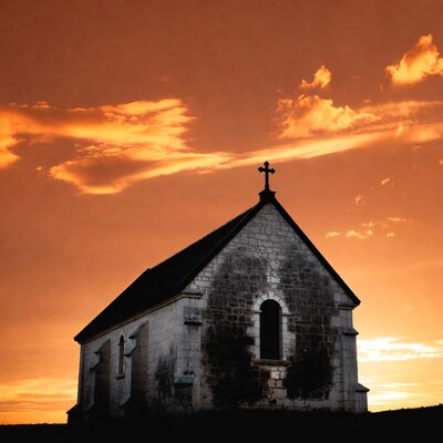 Stone chapel silhouetted against sunset