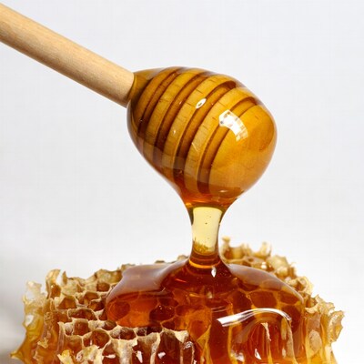 Honey dripping from wooden spoon