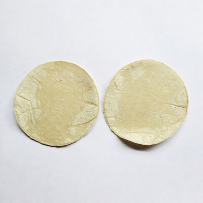 Two corn tortillas on white background