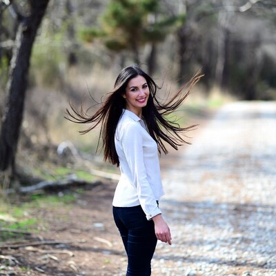 Woman with flowing hair in forest path