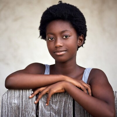 African-American girl leaning on wooden fence