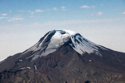 Snow-capped volcano under blue sky