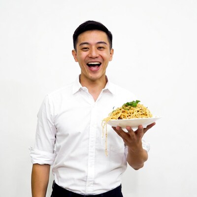 Asian man holding spaghetti plate