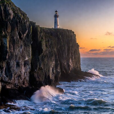 Lighthouse on Cliff at Sunset with Waves