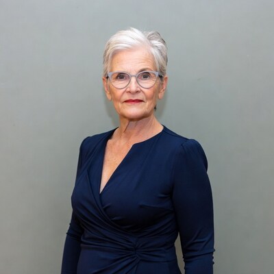 Elderly woman in navy dress and glasses