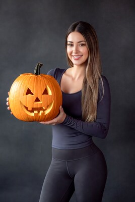 Woman holding jack-o-lantern pumpkin