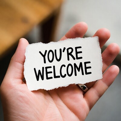 Hand holding You're Welcome sign