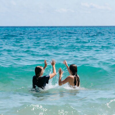 Two girls splashing in ocean water