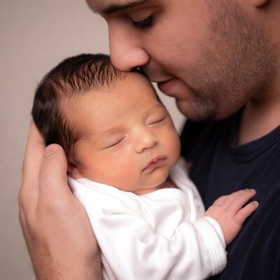 Father kissing newborn baby