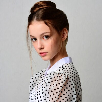 Girl in polka dot blouse profile view