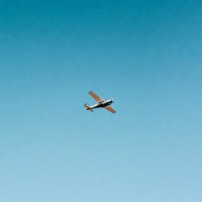 Small propeller plane flying in blue sky