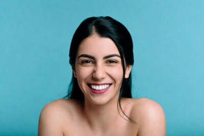 Smiling woman with black hair on blue background
