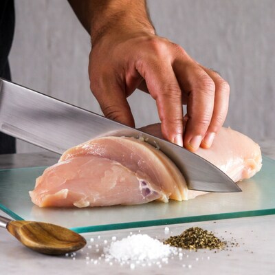 Man cutting raw chicken breast