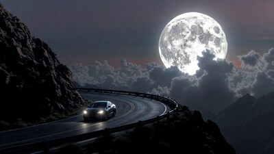 Tesla driving mountain road full moon