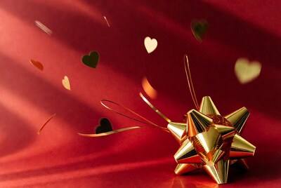 Golden bow with flying hearts on red