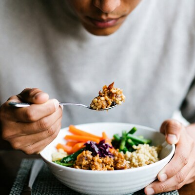 Man eating vegetable quinoa bowl
