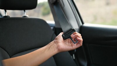 Woman buckling seatbelt in car