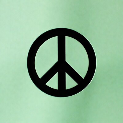 Black peace symbol on green background