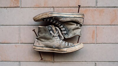 Worn Converse sneakers on brick wall