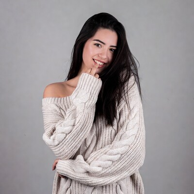 Smiling Latina woman in off-shoulder sweater