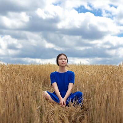 Asian woman sitting in wheat field