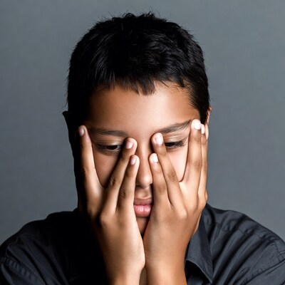 Boy covering face with hands