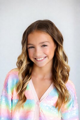Smiling girl in rainbow sequin cardigan
