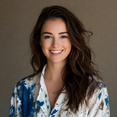 Smiling woman in paint-splattered shirt