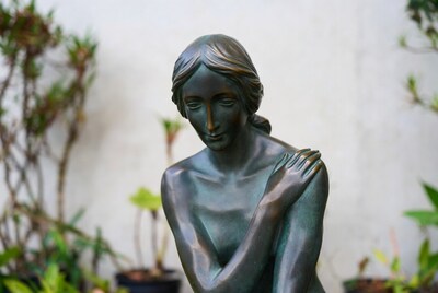 Bronze nude woman statue with plants