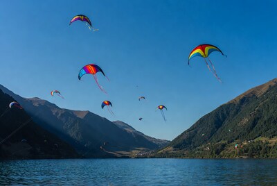 Colorful kites flying over lake mountains