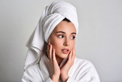 Woman in towel touching face