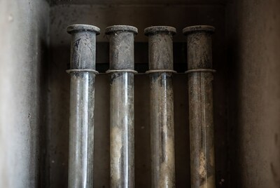 Four Dusty Glass Tubes in Concrete Wall