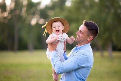 Father holding laughing baby girl