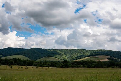Green mountains under cloudy sky