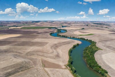 Aerial view of river winding through farmland
