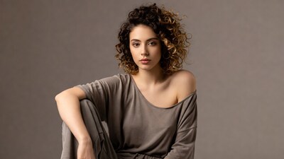 Woman with curly hair in off-shoulder top