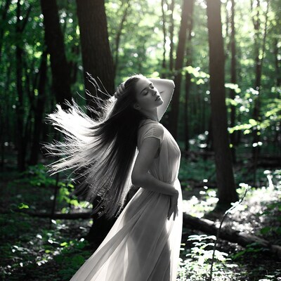 Woman with flowing hair in forest