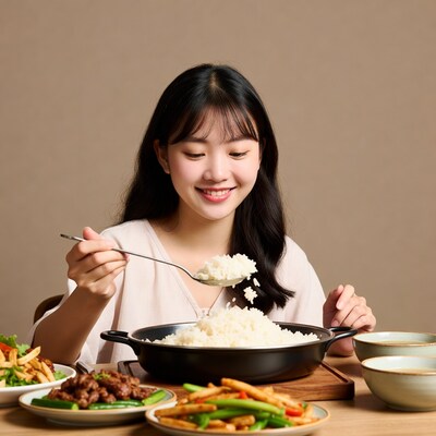 Asian woman eating rice with spoon