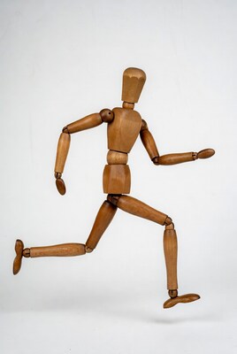 Wooden artist mannequin running pose