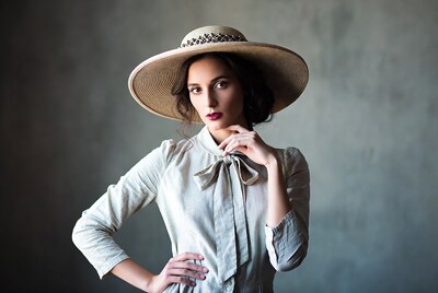 Woman in wide-brim hat posing thoughtfully