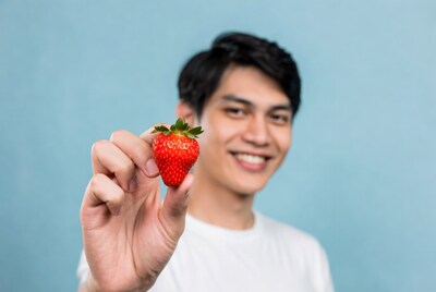Asian man holding strawberry