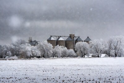 Grain Silos in Snowy Field