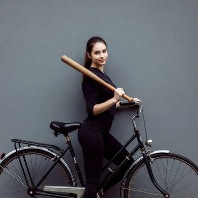 Woman with baseball bat by bicycle