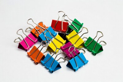 Colorful binder clips on white background