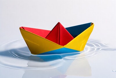 Colorful origami boat on water