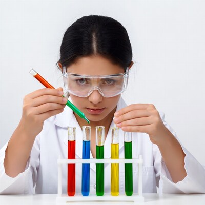 Asian girl scientist mixing colored liquids